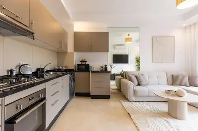 a kitchen and living room with a couch and a table at Escapade relaxante au Domaine NORIA in Marrakech