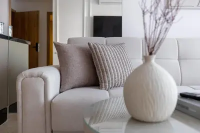 a living room with a white couch and a vase on a table at Escapade relaxante au Domaine NORIA in Marrakech