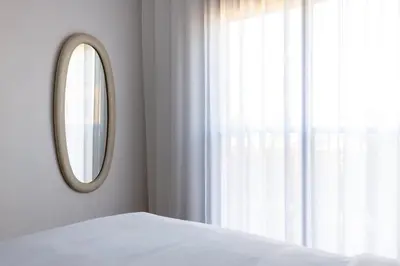 a bedroom with a mirror and a bed and a window at Escapade relaxante au Domaine NORIA in Marrakech