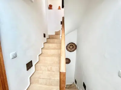 a staircase in a house with white walls and wooden railings at Riad Fleur de Kasbah in Marrakech
