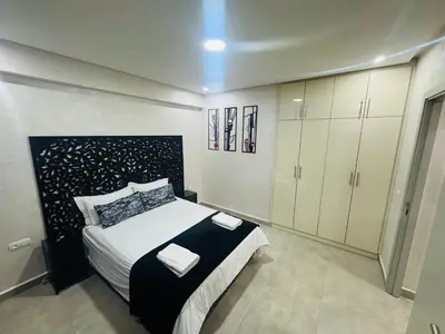 a bedroom with a large bed and white cabinets at New Résidence Miramas 2 in Marrakech