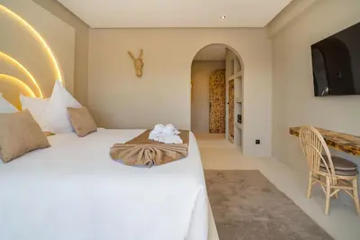 a bedroom with a white bed and a chair at Villa Bali Amelkis in Marrakech