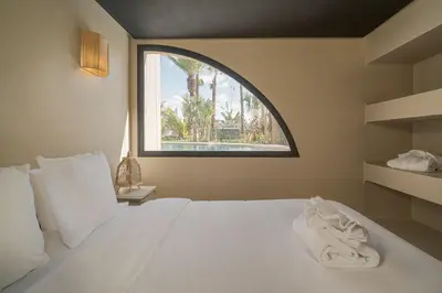 a bedroom with a large white bed with a window at Villa Bali Amelkis in Marrakech
