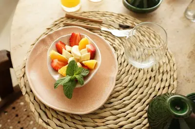a bowl of fruit on a plate on a table at Riad Casa Léa - Bassin chauffé - Petits déjeuners in Marrakech