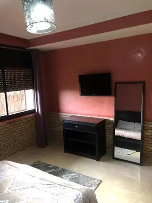 a bedroom with a mirror and a tv on the wall at - Résidence Babylone Y - Appartement 3 Chambres in Marrakech