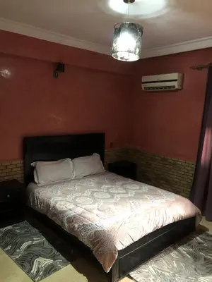 a bedroom with a bed in a room with red walls at - Résidence Babylone Y - Appartement 3 Chambres in Marrakech