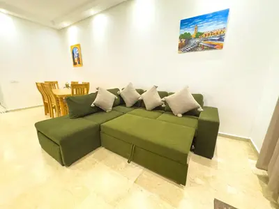 a green couch with pillows in a living room at Elegant 2-Bedroom Duplex Downtown Private Terrace in Marrakech