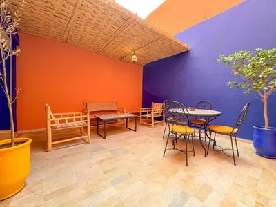 a patio with tables and chairs and a colorful wall at Elegant 2-Bedroom Duplex Downtown Private Terrace in Marrakech
