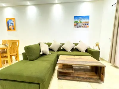 a living room with a green couch and a coffee table at Elegant 2-Bedroom Duplex Downtown Private Terrace in Marrakech