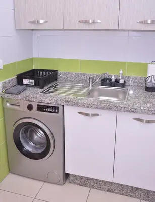 a kitchen with a sink and a washing machine at Darraha- Ideal for early & Late flights-Near Marrakech airport 10 min- menara Garden 5 min-Transport support in Marrakech