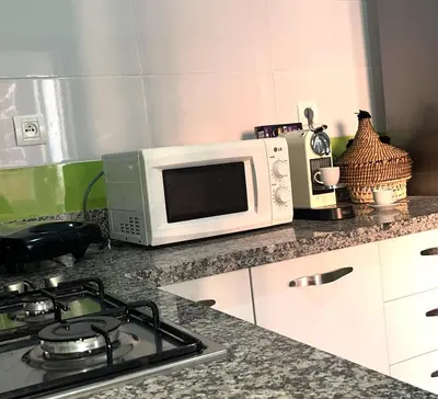 a kitchen counter with a microwave and a stove at Darraha- Ideal for early & Late flights-Near Marrakech airport 10 min- menara Garden 5 min-Transport support in Marrakech
