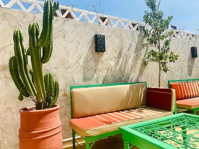 a patio with two chairs and a cactus at 66 Dar Aarab - Marrakech in Marrakech