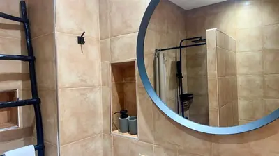 a bathroom with a shower with a round mirror at 66 Dar Aarab - Marrakech in Marrakech