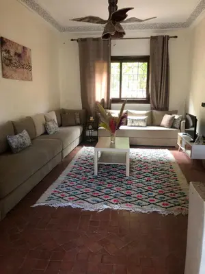 a living room with a couch and a table on a rug at Ghazaly house in Marrakech