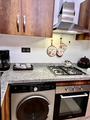 a kitchen with a stove and a washing machine at séjournée chez mayaa in Marrakech