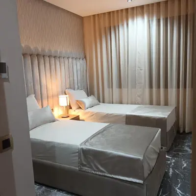 a hotel room with two beds and a window at Modern 2-Bedroom Family Flat in Central Marrakech in Marrakech