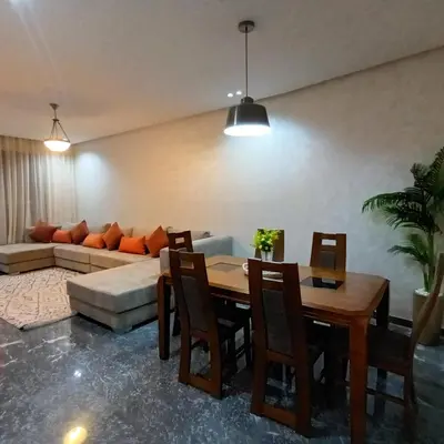 a living room with a table and a couch at Modern 2-Bedroom Family Flat in Central Marrakech in Marrakech