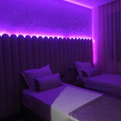 a room with two beds with purple lights on it at Modern 2-Bedroom Family Flat in Central Marrakech in Marrakech