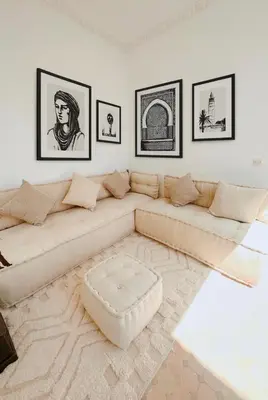 a white living room with a couch and pictures on the wall at Riad Solila, Fabuleux riad avec 4 Suites, Piscine Chauffée et Rooftop - 5 min de Jamaa El Fna in Marrakech