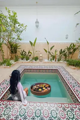 a doll sitting in a pool with a bowl of food at Riad Solila, Fabuleux riad avec 4 Suites, Piscine Chauffée et Rooftop - 5 min de Jamaa El Fna in Marrakech