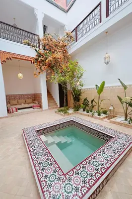 a swimming pool in the middle of a house at Riad Solila, Fabuleux riad avec 4 Suites, Piscine Chauffée et Rooftop - 5 min de Jamaa El Fna in Marrakech