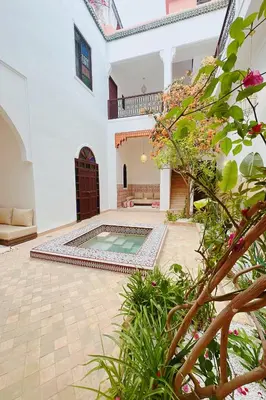 a courtyard with a swimming pool in a house at Riad Solila, Fabuleux riad avec 4 Suites, Piscine Chauffée et Rooftop - 5 min de Jamaa El Fna in Marrakech