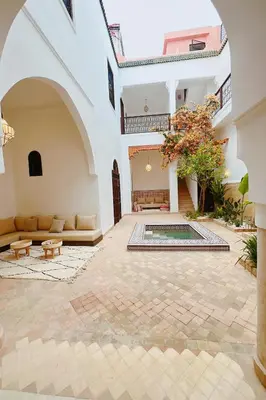 a courtyard with a pool in a building at Riad Solila, Fabuleux riad avec 4 Suites, Piscine Chauffée et Rooftop - 5 min de Jamaa El Fna in Marrakech
