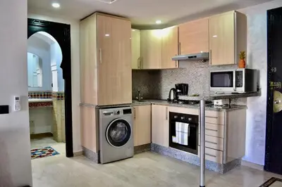a kitchen with a washing machine and a microwave at In Gueliz, Chic and Ethnic with a palm view in Marrakech