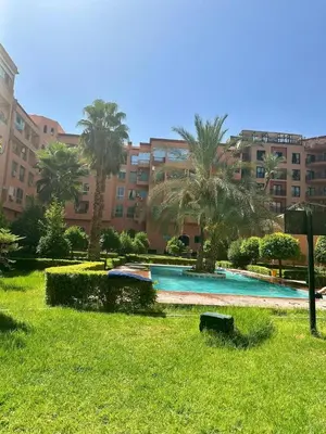 a swimming pool in a park with palm trees and a building at Modern & Chic Duplex Near The Center, Brand New in Marrakech