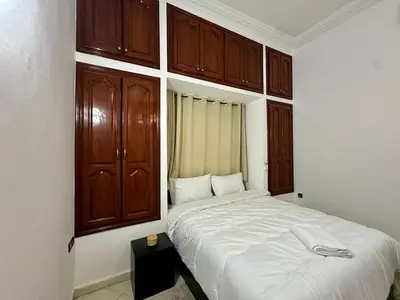 a bedroom with a large bed with wooden cabinets at Modern & Chic Duplex Near The Center, Brand New in Marrakech