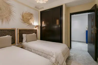 a bedroom with two beds and a door to a room at Gueliz's Sun Marrakesh Centre in Marrakech