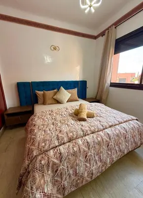 a bedroom with a bed with two teddy bears on it at Appartement Belle vue sur l'atlas in Marrakech