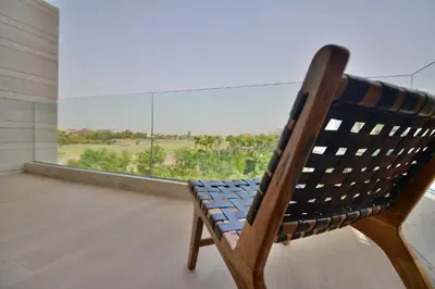 a wooden chair sitting in front of a large window at Villa Luxe 5 Suites & Piscine in Marrakech