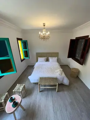 a bedroom with a large bed and a chandelier at Riad For families and groups in Marrakech