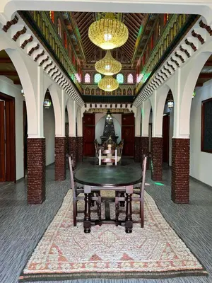 a room with a table and chairs and a chandelier at Riad For families and groups in Marrakech