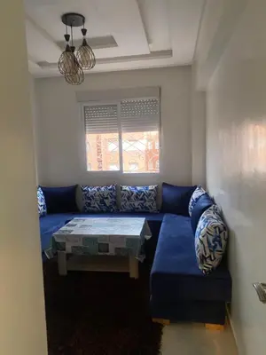 a living room with a blue couch and a table at Marrakech Bassatine targa in Marrakech