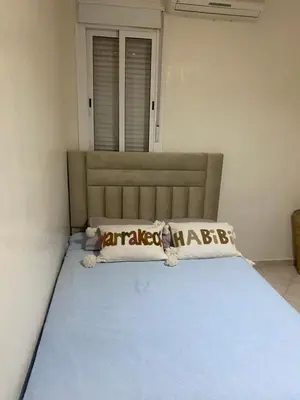 a bedroom with a bed with a blue bedspread and two pillows at Marrakech Bassatine targa in Marrakech