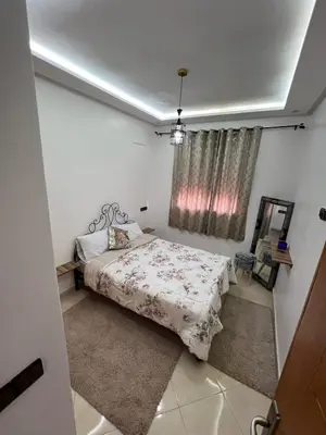 a bedroom with a bed and a mirror and a window at Nice apartment in Marrakech