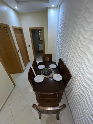 a table and chairs in a room with a wall at Nice apartment in Marrakech
