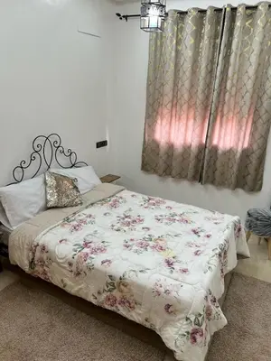 a bedroom with a bed with a floral comforter at Nice apartment in Marrakech