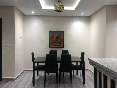 a dining room with a black table and chairs at APPARTEMENT MODERNE AU CENTRE m in Marrakech