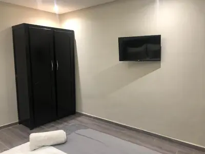 a room with a black cabinet and a flat screen tv at APPARTEMENT MODERNE AU CENTRE m in Marrakech