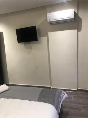 a bedroom with a bed and a air conditioner on the wall at APPARTEMENT MODERNE AU CENTRE m in Marrakech
