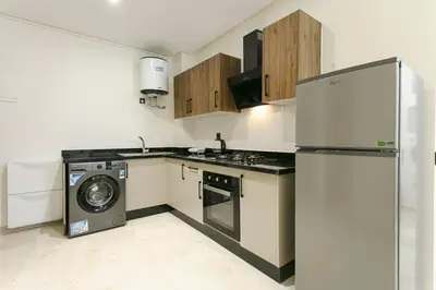 a kitchen with a refrigerator and a washing machine at Signature Suite Private Pool in Marrakech