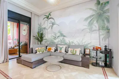a living room with a couch and a palm mural at Villa Dar Cactus piscine chauffée in Marrakech