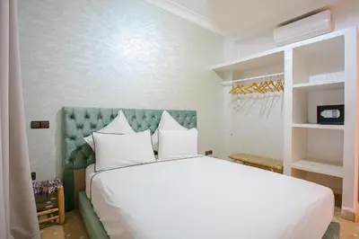 a bedroom with a large white bed with white pillows at Villa Dar Cactus piscine chauffée in Marrakech