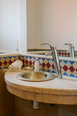 a bathroom counter with a sink and a mirror at Villa Dar Cactus piscine chauffée in Marrakech