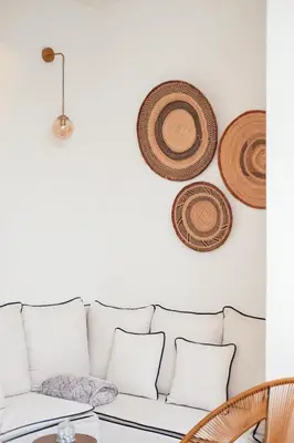 a living room with a white couch and straw hats on the wall at Dar Baraï in Marrakech