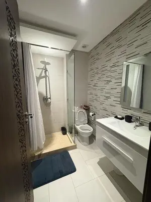 a bathroom with a toilet and a shower and a sink at Appartement Vue sur piscine in Marrakech