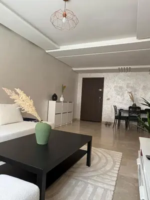 a living room with a couch and a table at Appartement Vue sur piscine in Marrakech